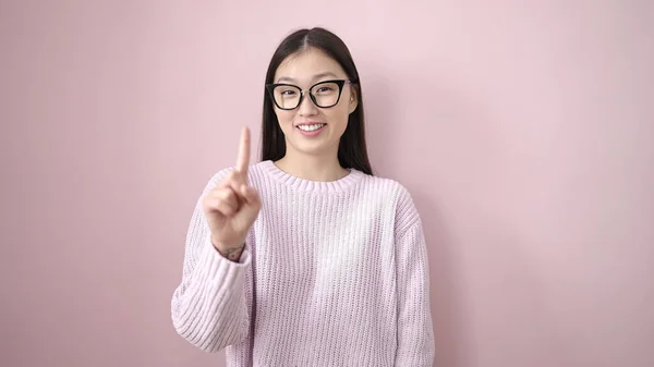 年轻的中国女人带着自信微笑 在孤立的粉色背景下表达自己的想法 — 图库照片