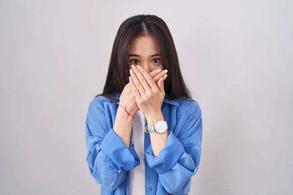 白い背景の上に立つ若い中国人女性は間違いのための手で口をカバーショックを受けた 秘密の概念 — ストック写真