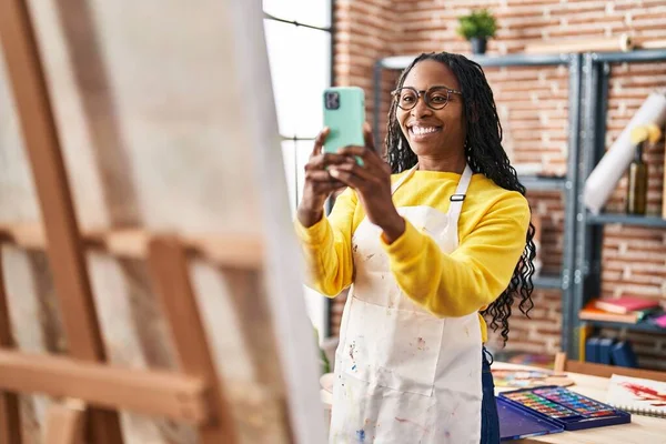 非洲裔美国妇女艺术家通过智能手机在艺术工作室作画 — 图库照片