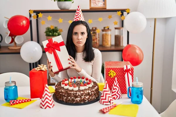 Mujer Hispana Celebrando Cumpleaños Con Torta Sosteniendo Presente Escéptico Nervioso — Foto de Stock