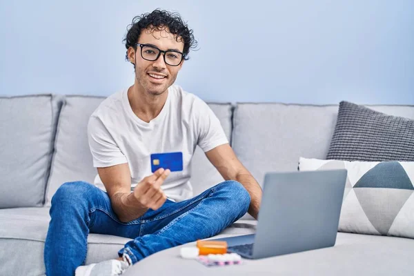 Молодий Іспаномовний Чоловік Використовує Ноутбук Кредитну Картку Сидячи Дивані Вдома — стокове фото