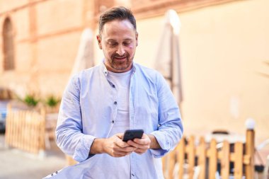 Young caucasian man smiling confident using smartphone at street