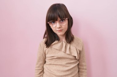 Yüzünde ciddi bir ifade olan gözlük takan küçük İspanyol kız. Basit ve doğal bir şekilde kameraya bakıyorsun.. 