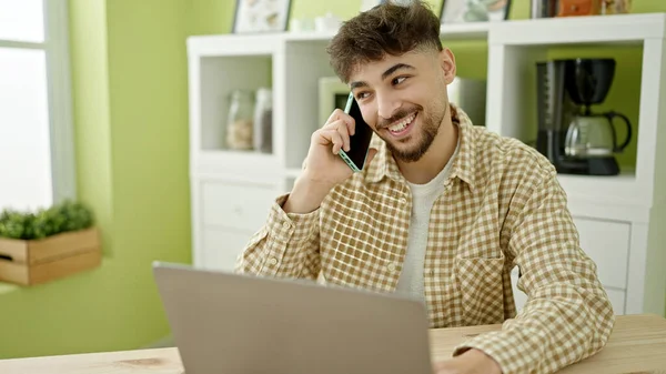Mladý Arabský Muž Pomocí Notebooku Mluví Smartphone Doma — Stock fotografie