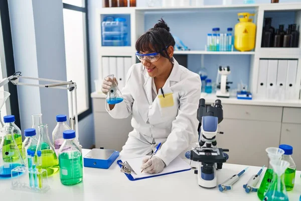 Young Beautiful Latin Woman Scientist Holding Test Tube Writing Report —  Fotos de Stock