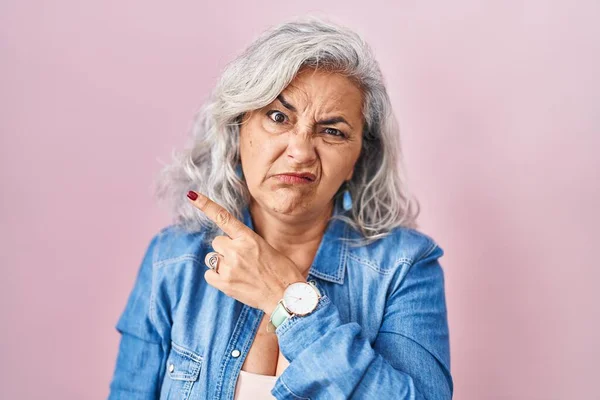 Pembe Arka Planda Gri Saçlı Orta Yaşlı Bir Kadın Endişeli — Stok fotoğraf