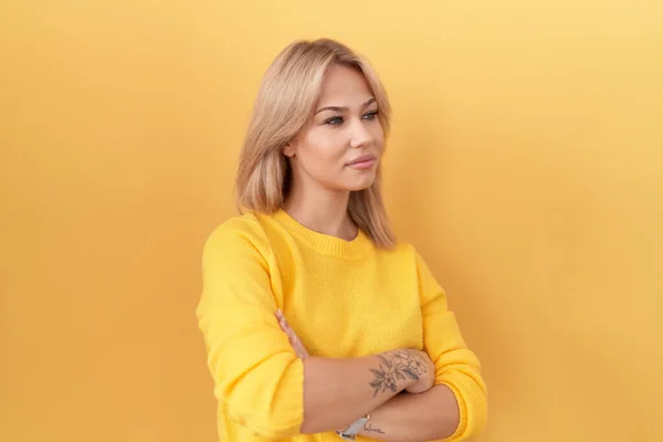 Jovem Caucasiana Vestindo Camisola Amarela Olhando Para Lado Com Braços — Fotografia de Stock