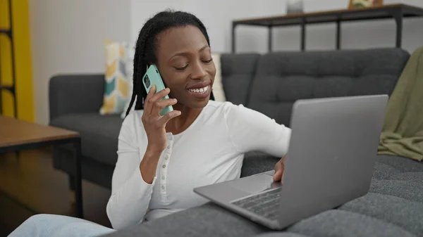 African American Woman Talking Smartphone Using Laptop Home — 图库照片