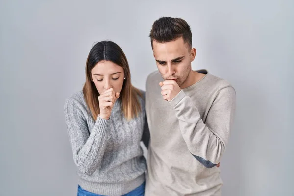 若いヒスパニック系のカップルは 寒さや気管支炎の症状として気分が悪く咳をして白い背景の上に立っています ヘルスケアの概念 — ストック写真