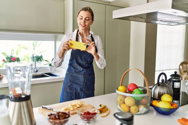 年轻的金发女人在厨房里做香蕉片 — 图库照片