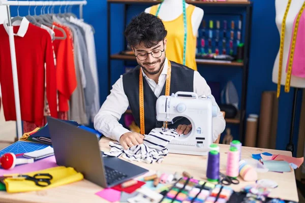Young Hispanic Man Tailor Using Sewing Machine Laptop Sewing Studio — Foto de Stock