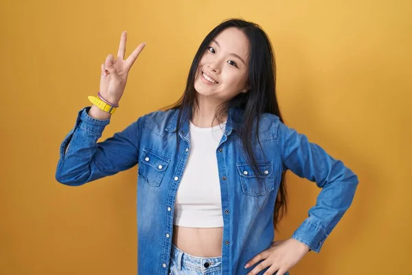 Młoda Azjatka Stojąca Nad Żółtym Tłem Uśmiechnięta Patrząca Kamerę Pokazująca — Zdjęcie stockowe