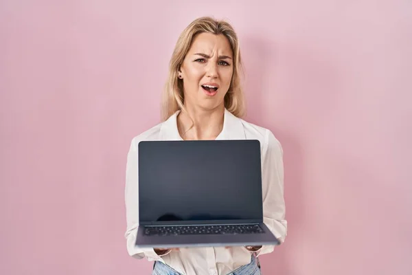 Mulher Branca Jovem Segurando Laptop Mostrando Tela Expressão Indolor Confuso — Fotografia de Stock