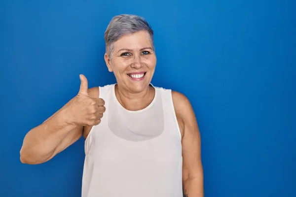 Orta Yaşlı Beyaz Bir Kadın Mavi Arka Planda Durup Mutlu — Stok fotoğraf