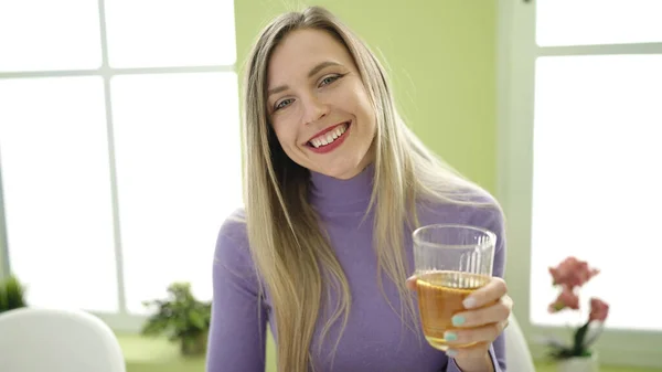 Ung Blond Kvinna Som Håller Ett Glas Infusion Sittandes Bordet — Stockfoto