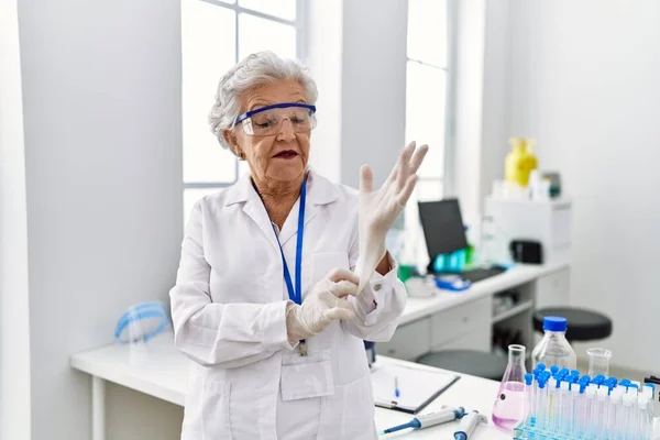 Starsza Siwowłosa Kobieta Mundurze Naukowca Rękawiczkach Laboratorium — Zdjęcie stockowe