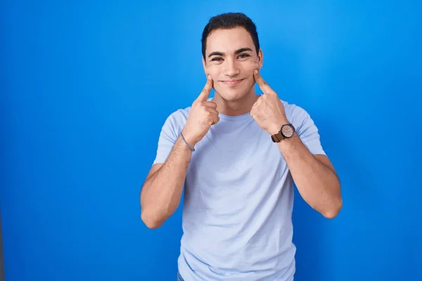 Joven Hombre Hispano Pie Sobre Fondo Azul Sonriendo Con Boca —  Fotos de Stock