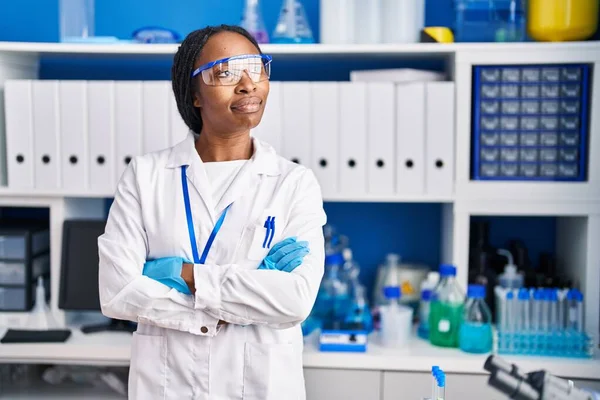 科学者の制服を着たアフリカ系アメリカ人女性が腕を組んでジェスチャー研究室 — ストック写真