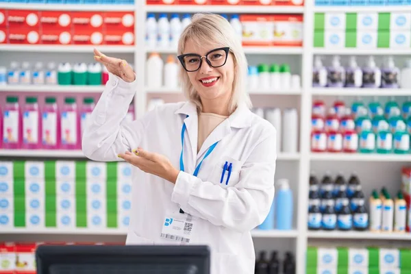 Young Caucasian Woman Working Pharmacy Drugstore Gesturing Hands Showing Big — Fotografia de Stock