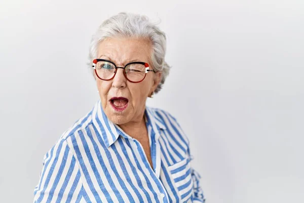 Starsza Kobieta Siwymi Włosami Stojąca Nad Białym Tłem Mrugająca Patrząc — Zdjęcie stockowe