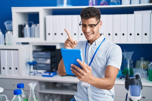 若いですヒスパニック男仕事で科学者研究室でビデオ通話笑顔幸せなポインティングとともに手と指で側面 — ストック写真