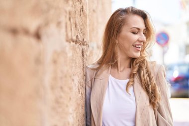 Parkta kendinden emin gülümseyen genç sarışın kadın.