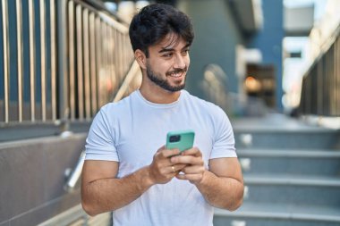 Sokakta akıllı telefon kullanan, kendine güvenen genç bir İspanyol.