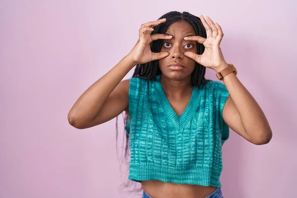 Молодой Африканский Американец Косичками Розовом Фоне Пытается Открыть Глаза Пальцами — стоковое фото
