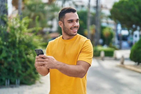 Ung Latinamerikansk Man Ler Säker Med Hjälp Smartphone Gatan — Stockfoto
