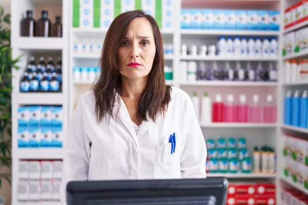 薬局で働く中年のブルネットの女性は疑い深い神経症で 問題のために動揺して眉をひそめている 否定的な人 — ストック写真