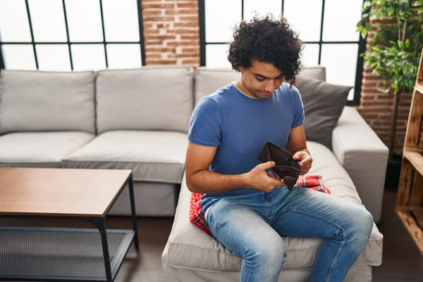 Young Hispanic Man Showing Empty Wallet Sitting Sofa Home — Stok fotoğraf