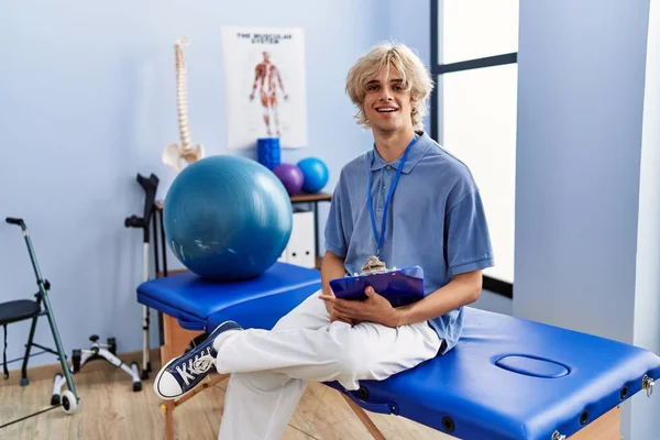 Genç Sarışın Adam Pisiyoterapist Elinde Rehabilitasyon Kliniğindeki Masaj Masasında Duran — Stok fotoğraf