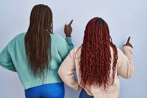 Two African Woman Standing Blue Background Posing Backwards Pointing Ahead — Stock Photo, Image