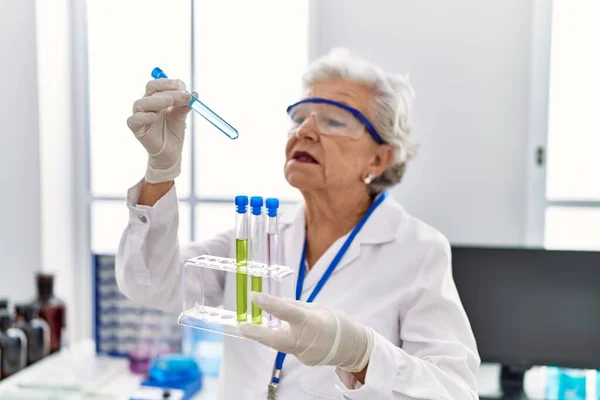 Starsza Siwowłosa Kobieta Mundurze Naukowca Trzymająca Probówki Laboratorium — Zdjęcie stockowe