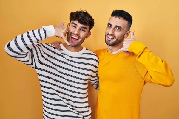 Jovem Hispânico Gay Casal Sobre Amarelo Fundo Sorrindo Fazendo Telefone — Fotografia de Stock