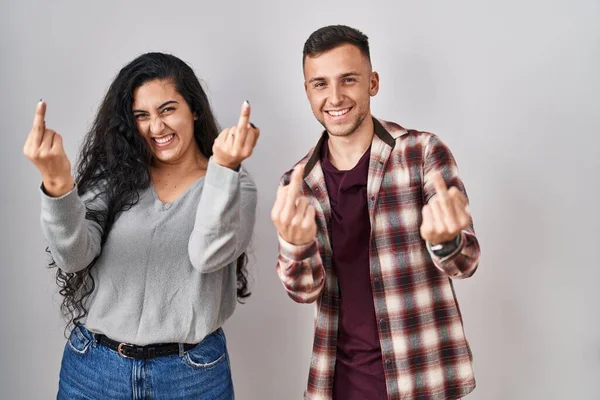 Young Hispanic Couple Standing White Background Showing Middle Finger Doing — стоковое фото