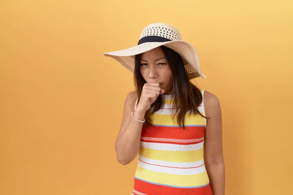 黄色の背景感に夏の帽子をかぶっている中国の中世の女性は具合が悪く 風邪や気管支炎の症状として咳をする ヘルスケアの概念 — ストック写真