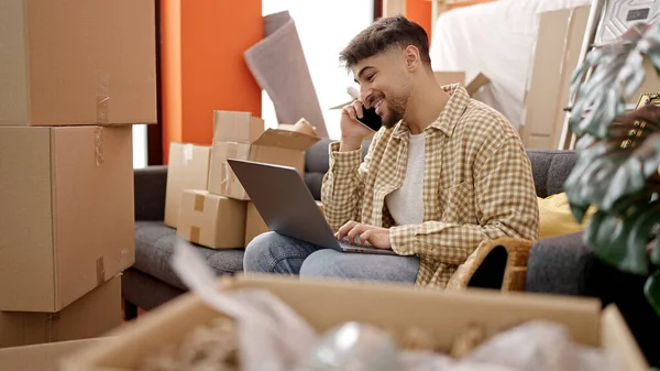 Jovem Árabe Homem Usando Laptop Falando Smartphone Nova Casa — Fotografia de Stock