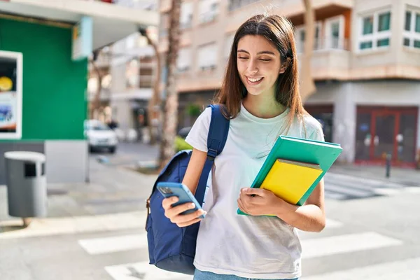 Young Beautiful Hispanic Woman Student Holding Books Using Smartphone Street — Foto Stock