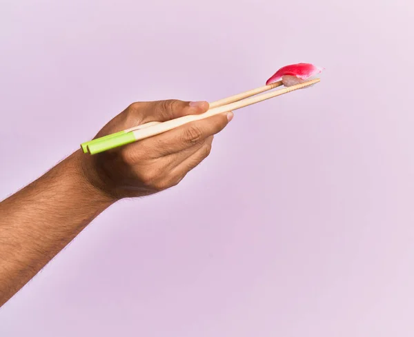 Ruka Muže Drží Ryby Nigiri Hůlkami Přes Izolované Růžové Pozadí — Stock fotografie