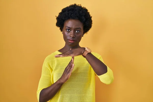 Afrykańska Młoda Kobieta Stojąca Nad Żółtym Studiem Wykonująca Gesty Dłońmi — Zdjęcie stockowe