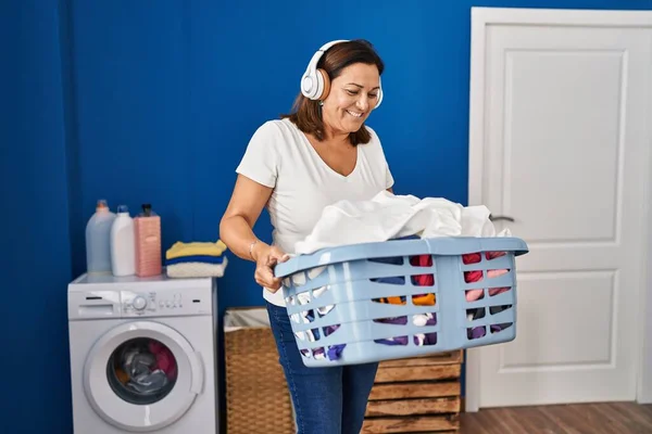 Middle Age Hispanic Woman Listening Music Holding Basket Clothes Laundry — ストック写真