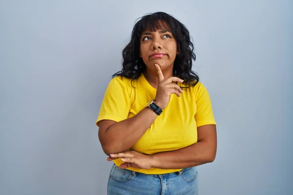 Hispanic Woman Standing Blue Background Thinking Concentrated Doubt Finger Chin — Stock Photo, Image