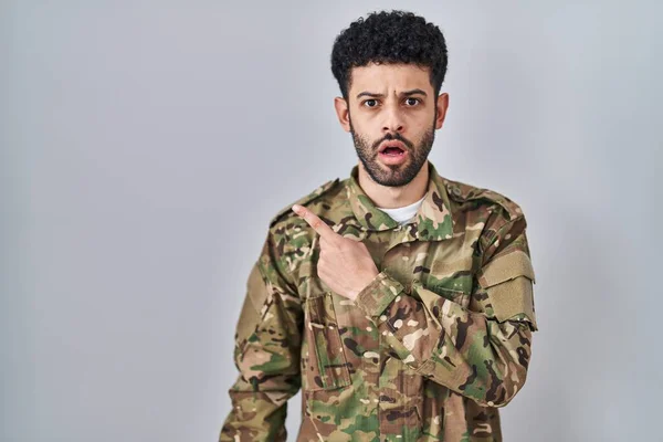 Arab Man Wearing Camouflage Army Uniform Surprised Pointing Finger Side — Stock Photo, Image