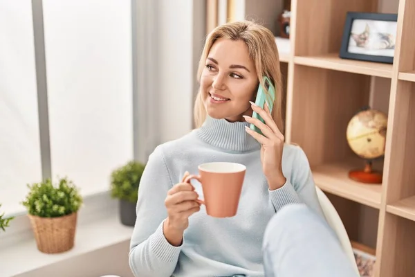 Young Blonde Woman Talking Smartphone Drinking Coffee Home — Fotografia de Stock