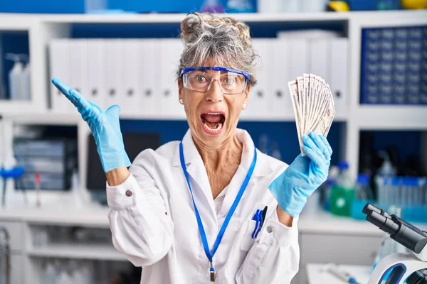 Femme Âge Moyen Travaillant Laboratoire Scientifique Tenant Des Dollars Célébrant — Photo