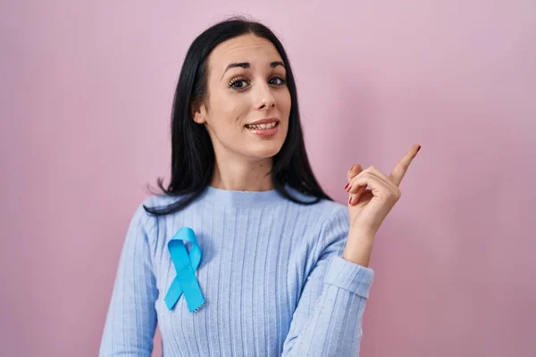 Hispanic Woman Wearing Blue Ribbon Smiling Happy Pointing Hand Finger — Stock Photo, Image