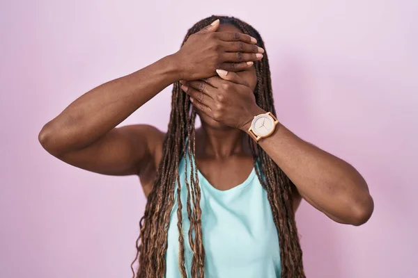 ピンクの背景に立っているアフリカ系アメリカ人の女性は 手で目と口を覆い 驚いてショックを受けました 感情を隠す — ストック写真