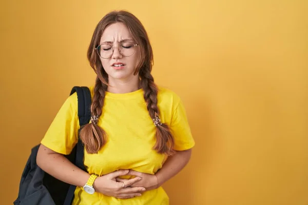 Young Caucasian Woman Wearing Student Backpack Yellow Background Hand Stomach — Stock Photo, Image