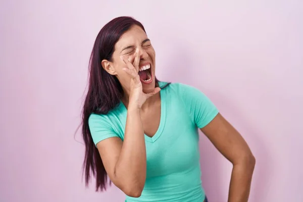 Молода Іспаномовна Жінка Стоїть Над Рожевим Тлом Кричить Кричить Голосно — стокове фото
